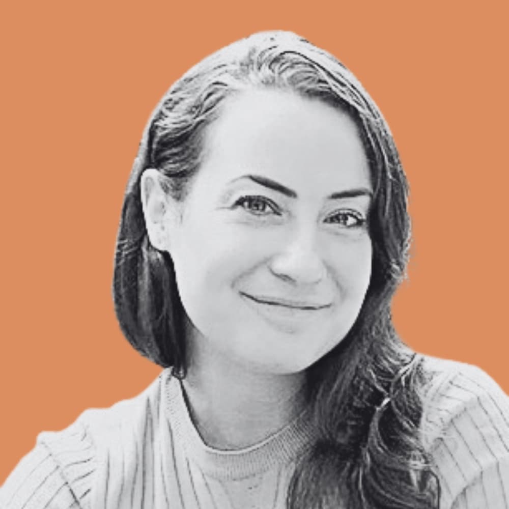 SMB Marketing agency team member Marie-Christine in black and white with a light orange background.